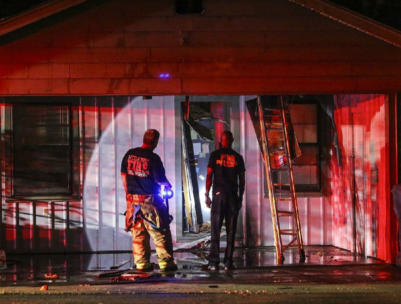 Little Rock Fire Capt. Steve Green (left) and Chief Fire Marshal Joseph Gray look over the scene of a suspected arson at a home in the 2100 block of Durwood Road on Tuesday night in Little Rock.