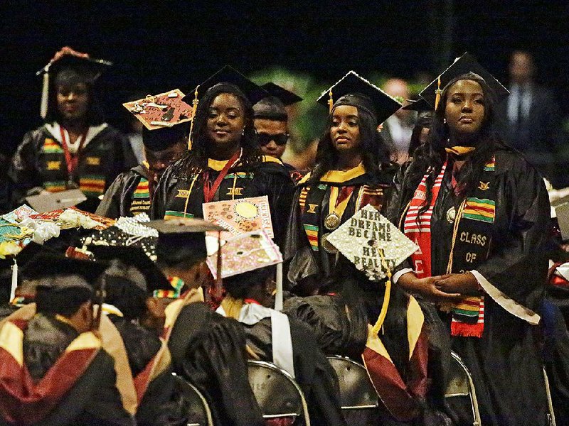 Some graduates stand and turn their backs during a commencement speech Wednesday by Education Secretary Betsy DeVos at Bethune-Cookman University in Daytona Beach, Fla.