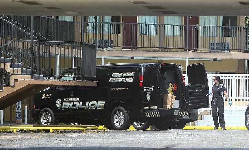 Hot Springs Police Department crime scene investigator Jenifer Brizo works Wednesday at the Econo Lodge at 1204 Central Ave., where two people were shot just before midnight Tuesday. 