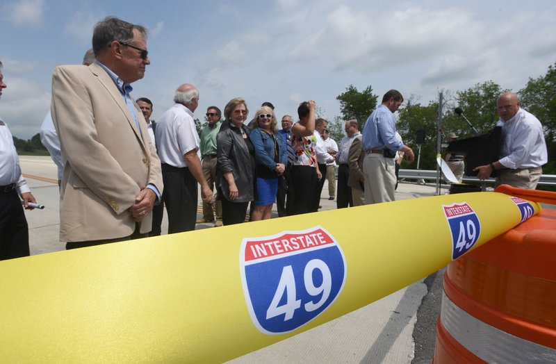 NWA Democrat-Gazette/FLIP PUTTHOFF Elected officials and highway department officials gather Wednesday to cut a ribbon dedicating a section of the Bella Vista bypass. The route is planned to eventually be part of Interstate 49.