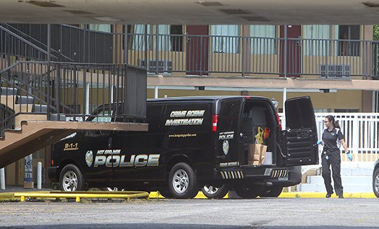 The Sentinel Record/Richard Rasmussen MOTEL SHOOTING: Hot Springs Police Department crime scene Investigator Jennifer Brizo collects items at the Econo Lodge, 1204 Central Ave., on Wednesday, where two people were shot while allegedly forcing their way into a room.