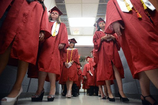 Springdale High School graduates walk out in pairs Saturday, May 17, 2014, at Bud Walton Arena in Fayetteville. Springdale High School had more than 600 students complete graduation requirements in order to get their diploma.