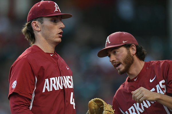 Arkansas starter Trevor Stephan (left) is greeted at the dugout door by reliever Josh Alberius against Mississippi State Saturday, March 18, 2017, during the first inning at Baum Stadium in Fayetteville. 