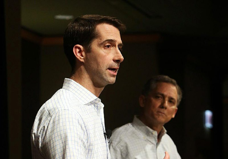  Senator Tom Cotton (left), with Congressman French Hill (right) looking on, answers a question at a joint town hall meeting at the Embassy Suites hotel in west Little Rock, April 17, 2017.