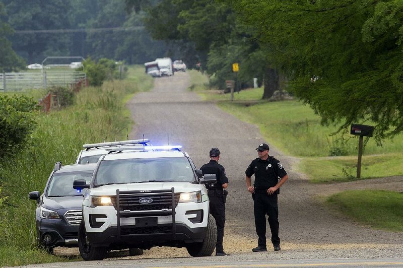 Police block Gum Springs Road in Yell County on Thursday after a man holed up in a home there for more than five hours. 