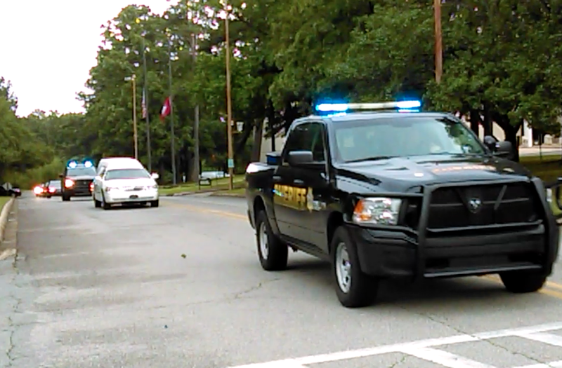 A line of law enforcement vehicles escorts a hearse carrying the body of Yell County Lt. Kevin Mainhart Friday morning.