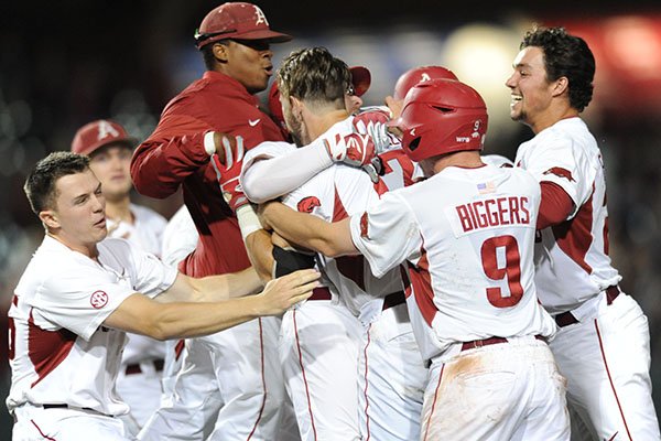 Arkansas players mob Luke Bonfield (17) after Bonfield's game-winning single in the ninth inning of a game against Vanderbilt on Friday, May 12, 2017, in Fayetteville. 