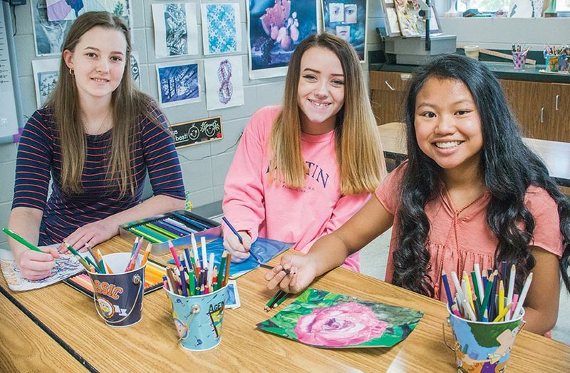 Three students from Pottsville Junior High School have won top awards in the 56th Young Arkansas Artists Exhibition at the Arkansas Arts Center in Little Rock. Shown here working on their art projects at school are McKenzie Horton, from left, Lorinda Nordin and Jada Parker.