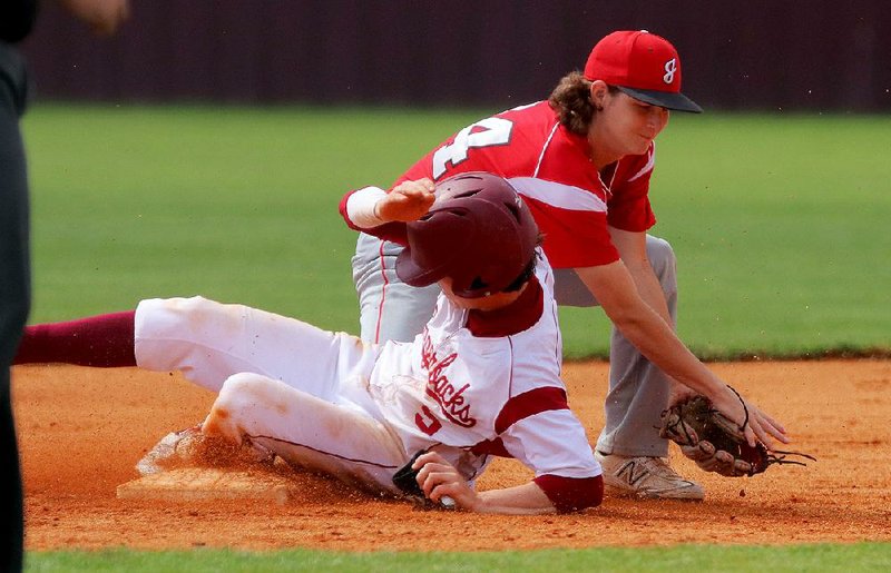Texarkana’s Gage Gore (bottom) slides safely into second with a stolen base under the tag from Jacksonville’s Trent Toney on Friday during the Razorbacks’ 11-1 victory over the Titans at the Class 6A state baseball tournament in Benton.