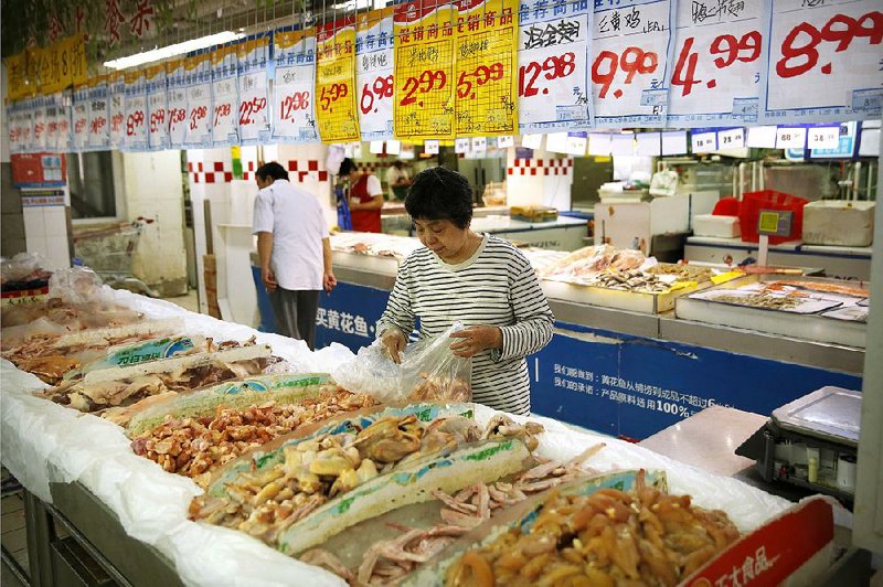 A woman browses the chicken section at a Beijing supermarket on Friday. As part of a new trade agreement, China will be allowed  to send cooked poultry to the U.S.