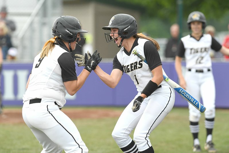 Bentonville High’s Cailey Cochran (left) and Megan Crownover celebrate Friday after beating Bentonville West during the 7A State Softball Tournament in Fayetteville.