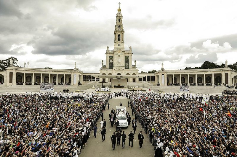Pope Francis leaves in his popemobile Saturday after canonizing two shepherd children during a Mass in Fatima, Portugal.