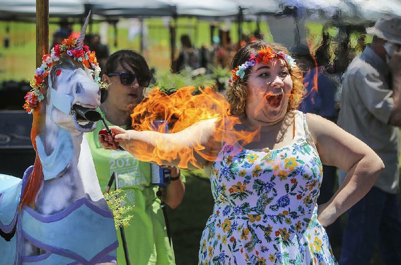 5/13/17
Arkansas Democrat-Gazette/STEPHEN B. THORNTON
Emily Jobe lights up Pele the fire-breathing unicorn for passersby during Saturday‚Äôs Mini Maker Faire in North Little Rock. Jobe and others from the Arkansas Innovation Hub built the unicorn for display in the Awesome World section of the fair.
