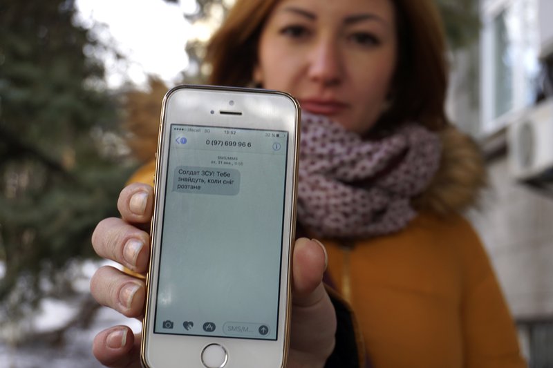 In this photo taken Wednesday, Feb. 22, 2017, television journalist Julia Kirienko holds up her smartphone to show a text message reading "Ukrainian soldiers, they'll find your bodies when the snow melts" in Kiev, Ukraine. Ukrainian soldiers fighting pro-Russian separatists are being bombarded by threats and disinformation via text message, the 21st-century equivalent of dropping leaflets on the battlefield. 