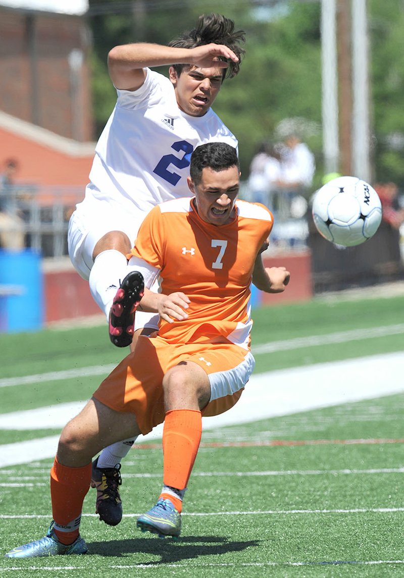 Rogers High’s Alex Valdez (2) and Rogers Heritage’s Pedro Garcia vie for the ball Saturday during a Class 7A state tournament semiÿnal at Mayo-Thompson Stadium at Northside High School in Fort Smith. Visit nwadg.com/photos for more photographs from the match.