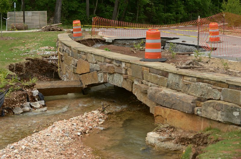 Barriers close off a section of road Thursday at Lake Atalanta in Rogers that remains closed after washing out in April flooding.