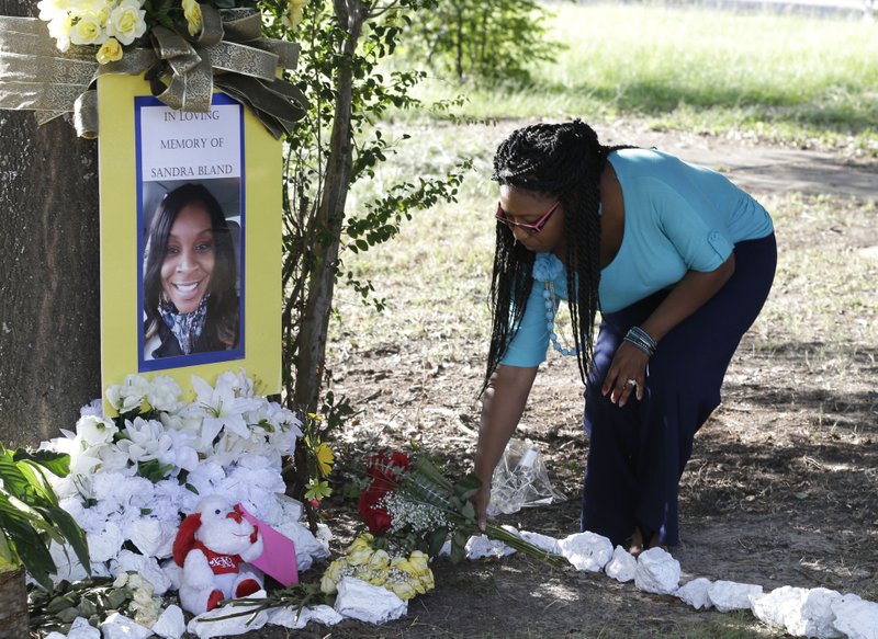 FILE - In this July 21, 2015 photo, Jeanette Williams places a bouquet of roses at a memorial for Sandra Bland near Prairie View A&M University, in Prairie View, Texas. 