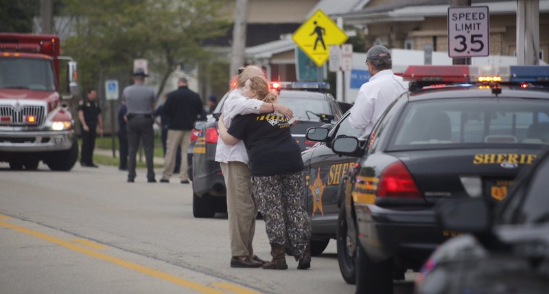 People hug as emergency personnel arrive to the scene of a shooting outside Pine Kirk nursing home in Kirkersville, Ohio on Friday, May 12, 2017. Authorities say Steven Eric Disario, who headed the Kirkersville Police Department, and two nursing home employees have been killed by a gunman who was later found dead inside the care facility.  (Tom Dodge/The Columbus Dispatch via AP)