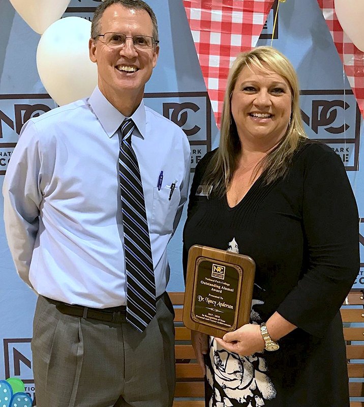 Submitted photo ALUMNI AWARD: President John Hogan, left, and National Park College recognized Cutter Morning Star Superintendent Nancy Anderson Thursday with the 2017 Outstanding Alumni Award during the annual Employee Recognition Day in the NPC Wellness Center gymnasium.