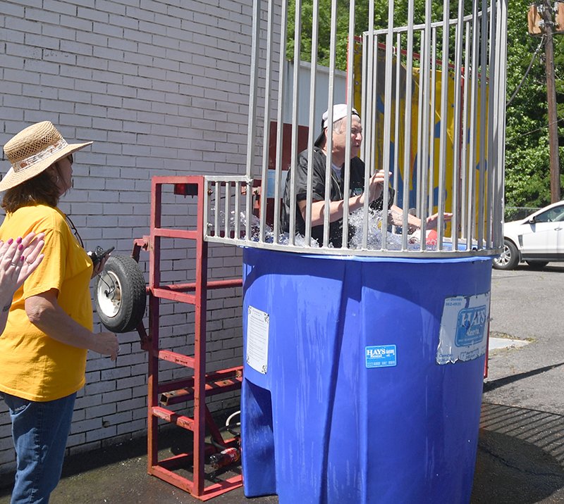The Sentinel-Record/Mara Kuhn TAKING THE PLUNGE: Steve Arrison, CEO of Visit Hot Springs, is plunged into the Hot Springs Civitan Club's dunk tank as Jo West Taylor cheers during SummerFest Uptown Saturday.