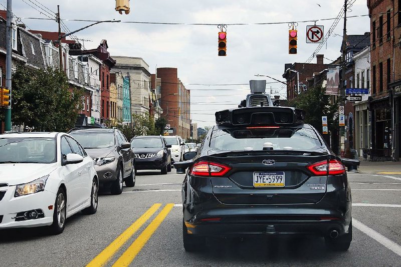 A self-driving Uber car stops at a red light on Liberty Avenue through the Bloomfield neighborhood of Pittsburgh in September.