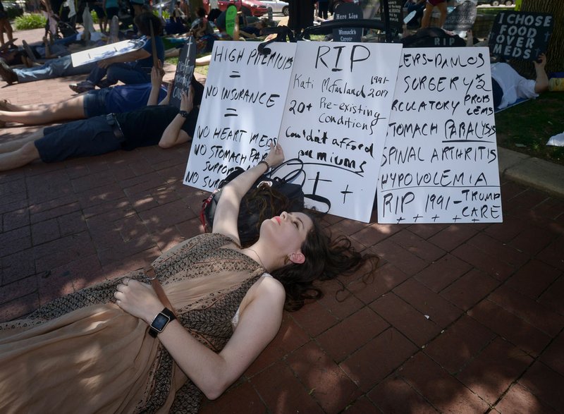 Kati McFarland of Springdale participates May 7 during a “Die-In for ACA” hosted by Ozark Indivisible on the Bentonville square.
