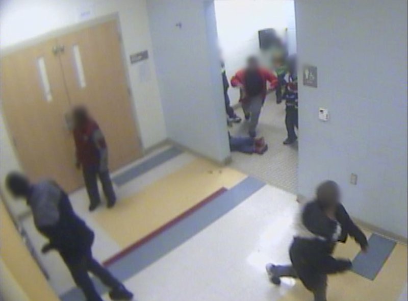 In this still image from a Jan. 24, 2017, surveillance video provided by Cincinnati Public Schools, the legs and feet of 8-year-old Gabriel Taye can be seen as he lies on the floor of a boys' bathroom after being knocked unconscious by another boy at Carson Elementary School. Two days later, Taye hanged himself with a necktie in the bedroom of his Cincinnati apartment. 