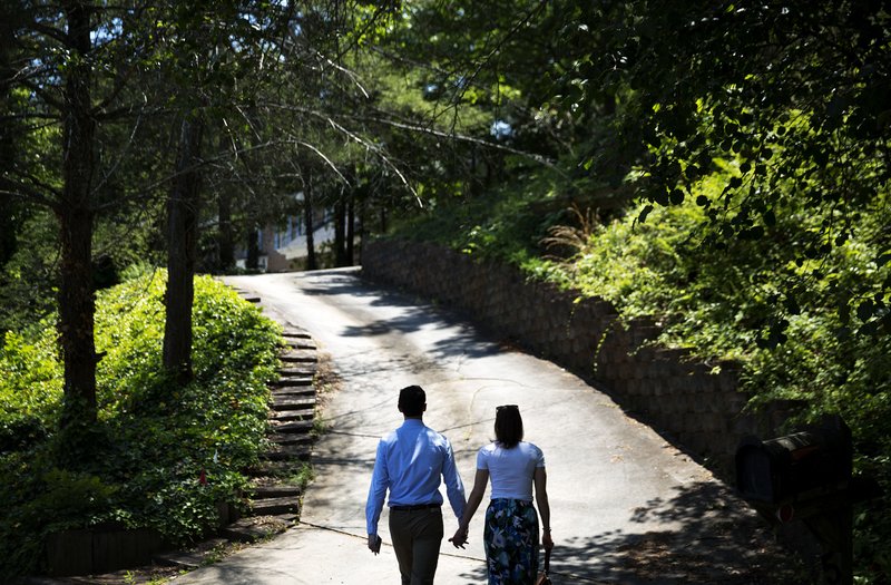 Jon Ossoff, left, a 30-year-old Democrat running for Congress in Georgia's traditionally conservative 6th Congressional District, and fiancee Alisha Kramer, walk up a driveway to knock on a door while campaigning in Sandy Springs, Ga., Thursday, May 11, 2017. Ossoff's fortunes in a June 20 matchup with Republican Karen Handel will be an early test of how the Republicans' vote to gut the Affordable Care Act and President Donald Trump's decision to fire the FBI director are playing with voters. Both parties see the Georgia race as an indicator for the 2018 midterm elections. 