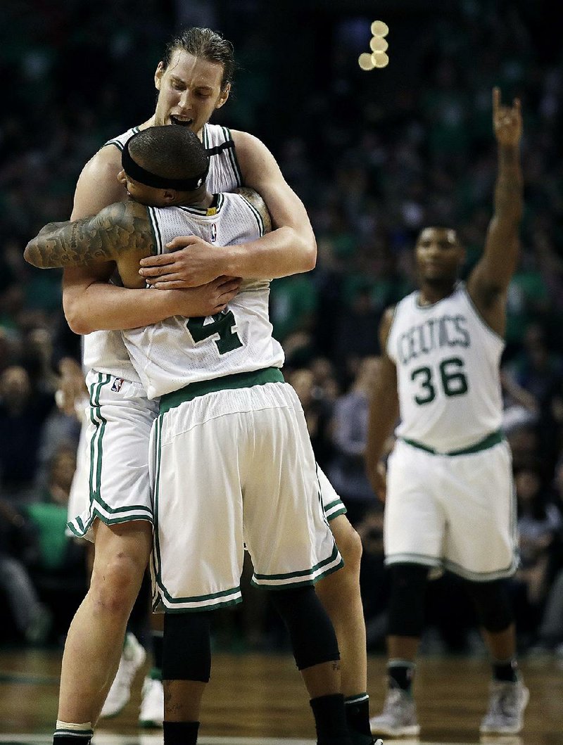 Boston guard Isaiah Thomas (center) and center Kelly Olynyk embrace during Game 7 of their NBA Eastern Conference semifinal Monday. Thomas scored 29 points and Olynyk added 26 points as the Celtics pulled away to beat the Wizards 115-105.