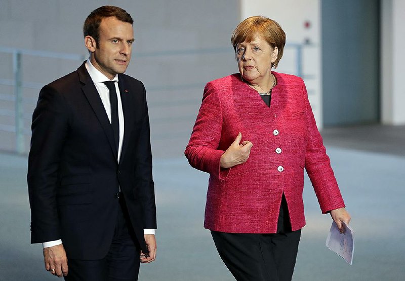 New French President Emmanuel Macron and German Chancellor Angela Merkel arrive Monday for a joint news conference as part of a meeting in Berlin during Macron’s fi rst foreign trip after his Sunday inauguration.