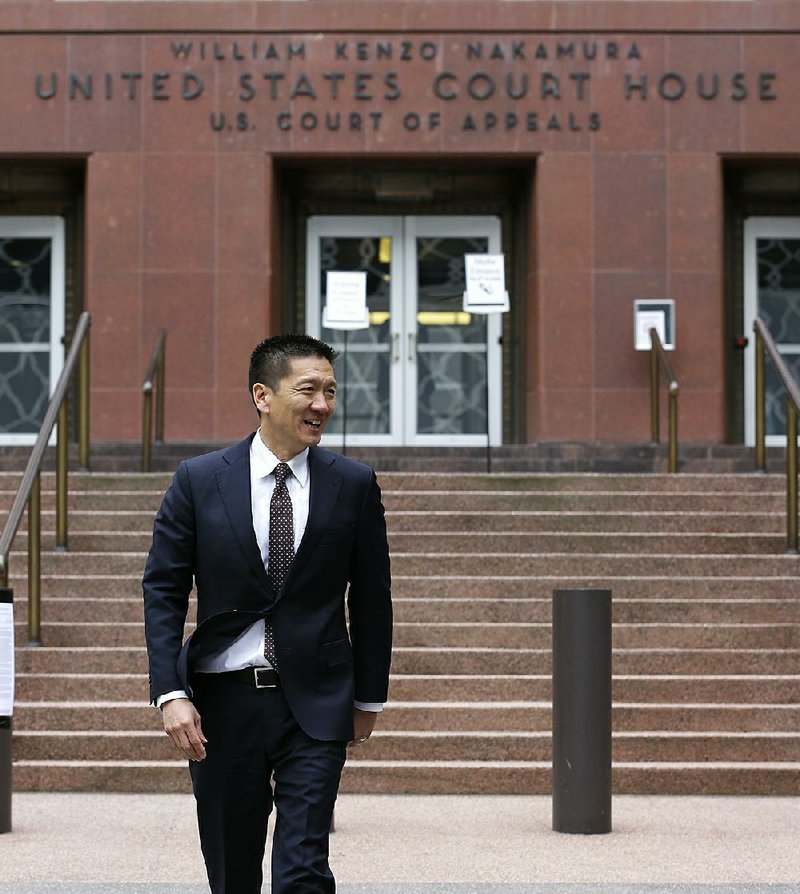 Hawaii Attorney General Doug Chin arrives to talk to reporters Monday outside a federal courthouse in Seattle.