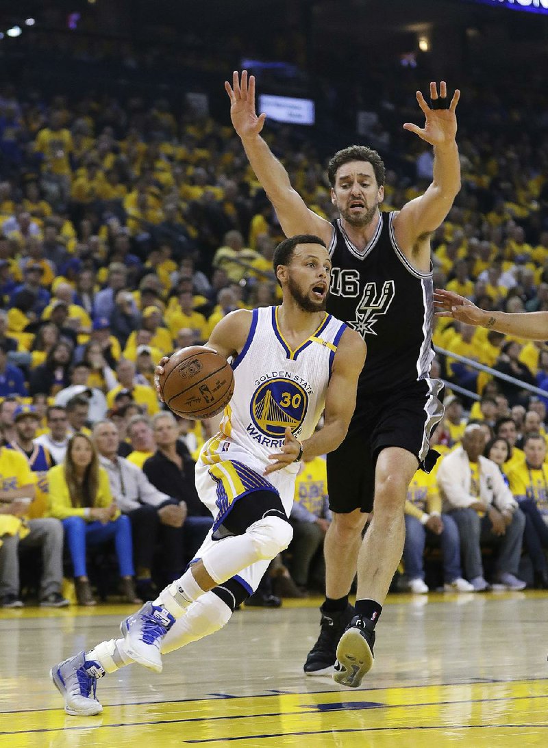 Golden State guard Stephen Curry (left) dribbles around San Antonio forward Pau Gasol during Game 2 of the NBA Western Conference ÿnals Tuesday night. Curry’s 29 points helped the Warriors grab a 2-0 series lead with a 136-100 victory.