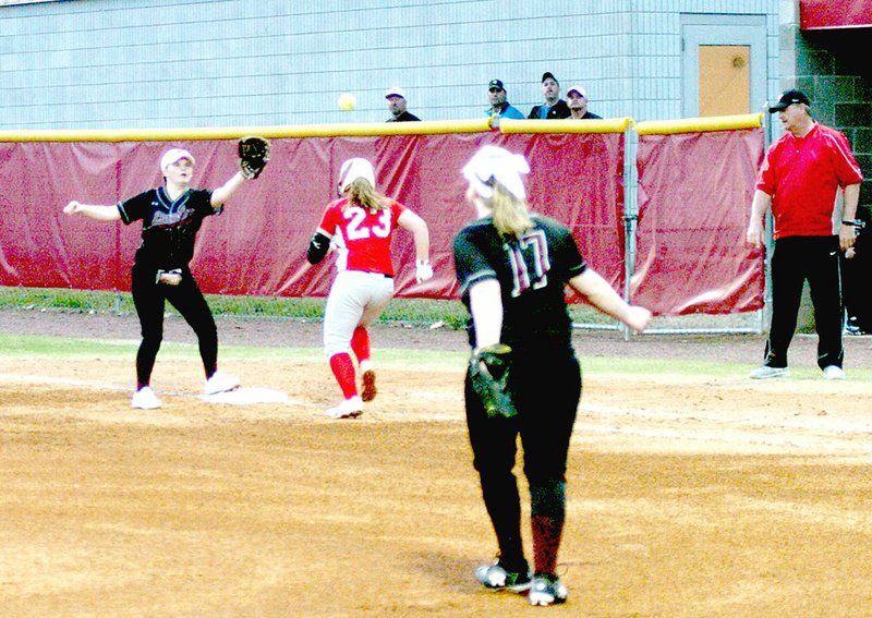 MARK HUMPHREY ENTERPRISE-LEADER Lincoln pitcher Ayden Massey watches as Farmington&#8217;s Carley Antwine tries to beat a throw to Tristan Cunningham at first during the Farmington/Fayetteville Invitational Softball tournament. The Lady Wolves lost a heartbreaking 1-0 first-round state tournament game to Heber Springs Thursday.