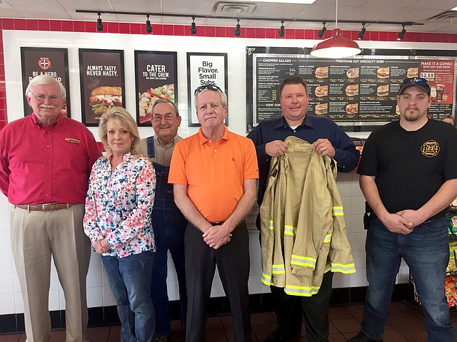 Submitted Photo The city of Gravette Fire Department received 20 sets of turnout gear valued at $9,717 at an awards ceremony Tuesday, May 2, at the Firehouse Subs restaurant in Bentonville. The grant award was funded through the Firehouse Subs Public Safety Foundation. Attending the awards presentation were Jim Maxwell (left), Firehouse Subs area representative; Tracy Bush, Firehouse Subs franchisee; Rod Clardy, Gravete city councilman; Carl Rabey, Gravette finance director; Lieutenant Dave Winter (holding coat), Gravette Fire Department; and Lieutenant Josh Blocker, Gravette Fire Department.