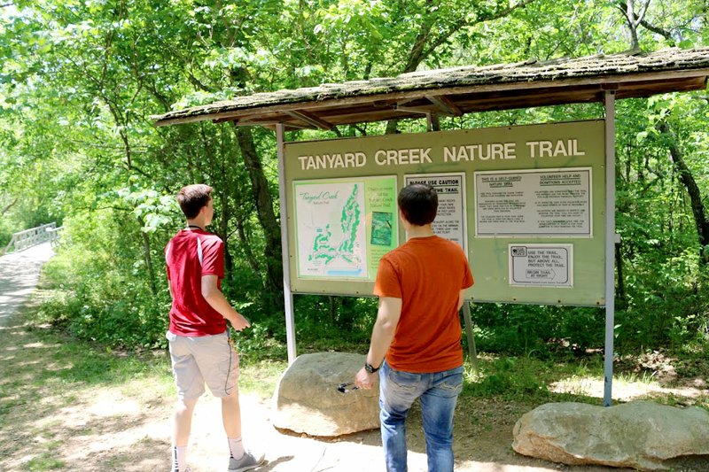 Photo by Isabella Dell Thomas Tryon (left) and Grayson Fordyce studied a map at the head of the Tanyard Creek Nature Trail in Bella Vista. Tryon, Fordyce and Isabella Dell are Gravette High School EAST students who have been creating a story map of the trail using computer mapping software.