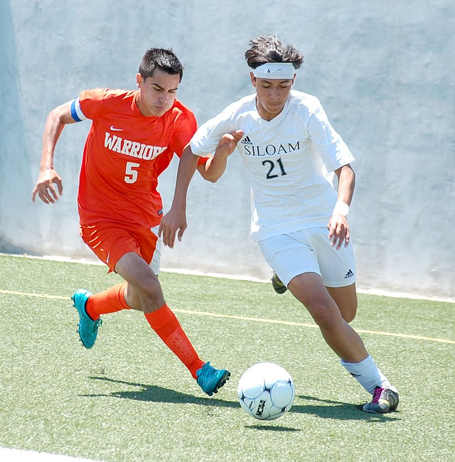 Graham Thomas/Herald-Leader Siloam Springs sophomore Christian Marroquin, right, runs by Little Rock Hall defender Dilan Veloso during the Class 6A state semifinals on Saturday at Panther Stadium. Marroquin scored the Panthers&#8217; only goal in regulation and also had a score in the penalty kicks period as Siloam Springs defeated Hall 1-1 (3-1 PKs) to advance to the state championship match. Marroquin leads the Panthers with 19 goals and 11 assists.