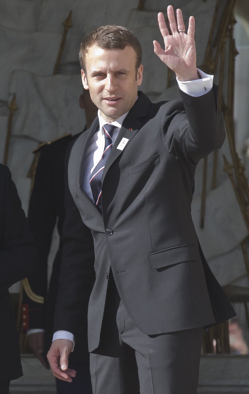 New French President Emmanuel Macron waves to the media after a meeting with the International Olympic Committee at the Elysee palace in Paris, France, May 16, 2017. France's new President Emmanuel Macron is hosting the International Olympic Committee to try to boost Paris' bid to beat out Los Angeles in the heated race for the 2024 Games. (AP Photo/Michel Euler)