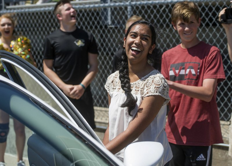 Apoorva Krovvidi, 17, smiles Tuesday as she realizes she won a 2016 Nissan Versa from McLarty Daniel Automotive of Bentonville in its car giveaway at Tiger Stadium in Bentonville. The dealership gave a car to a student in its Attendance is the Key initiative at Bentonville, West, Rogers and Heritage high schools. The Bentonville student had to meet attendance requirements to earn entries to the contest. The entries were pooled, then 10 names were drawn with each person getting a key to try on the car.