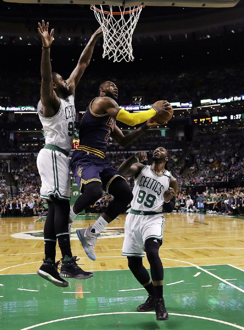 Cleveland forward LeBron James (center) splits Boston defenders Amir Johnson (left) and Jae Crowder during the ÿrst quarter in Game 1 of the NBA Eastern Conference ÿnals Wednesday. The Cavaliers never trailed in coasting to a 117-104 victory behind James’ 38 points and nine rebounds.