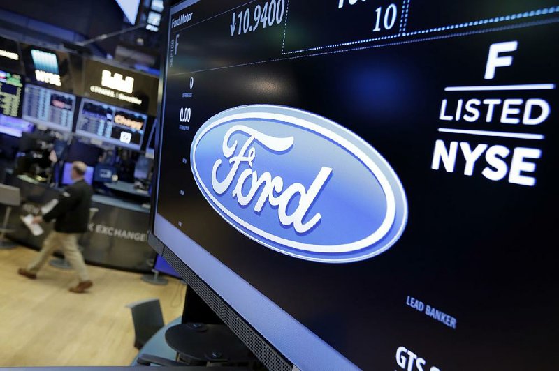 The logo for the Ford Motor Co. appears above a post on the floor of the New York Stock Exchange on Tuesday. Ford is moving ahead with plans to cut 10 percent of its salaried workforce.
