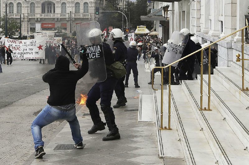 A protester attacks a police officer with a hammer Wednesday in Athens as an anti-austerity demonstration in the Greek capital turned violent.