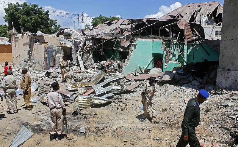 Somali soldiers gather at the site near Mogadishu where a car bomb went off Wednesday.