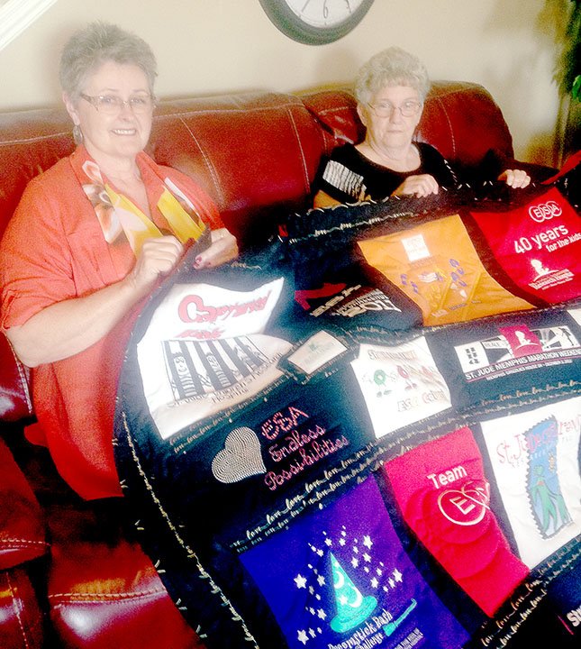 Sally Carroll McDonald County Press Bunker Hills Quilter Sam Alps, left, and President DeeDee Lewis show off Alps&#x2019; quilt that will be one of several on display at the club&#8217;s community quilt show this weekend at the Pineville Community Center. Alps created the T-shirt quilt for Epsilon Sigma Alpha. The creation will be auctioned off this summer at the ESA International Convention.