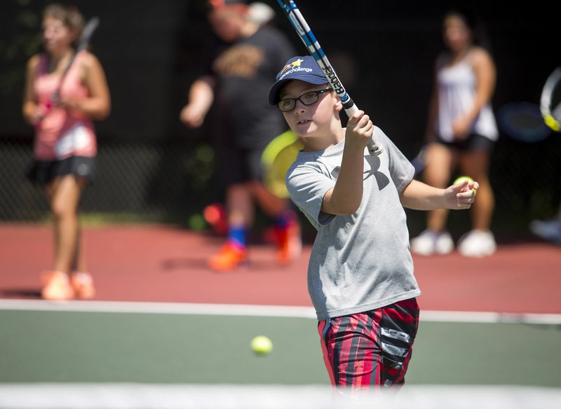 NWA Democrat-Gazette/JASON IVESTER Carter Helms of Bentonville returns a shot at the Kingsdale tennis center in Bella Vista. Carter and other youth participated in the annual 2016 Cancer Challenge junior tennis clinic and tournament. This year's event runs June 8-10, with events in Bella Vista, Bentonville and Springdale.