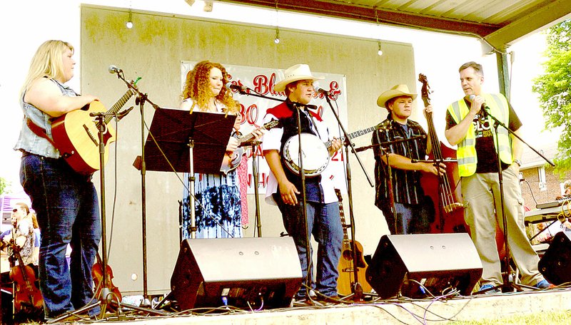 File photo Ken Schutten of the Anderson Betterment Club introduced the Ozark Wildfire Band at the Anderson Berries, Bluegrass &amp; BBQ Festival last year.