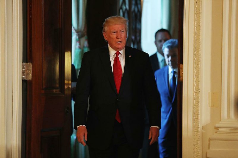President Donald Trump, followed by Colombian President Juan Manuel Santos, arrives for their joint news conference Thursday at the White House. Trump, who makes his ÿrst overseas trip today to Saudi Arabia, called the appointment of former FBI Director Robert Mueller as special counsel to oversee the investigation of possible Russian meddling in last year’s election “a very, very negative thing.” 