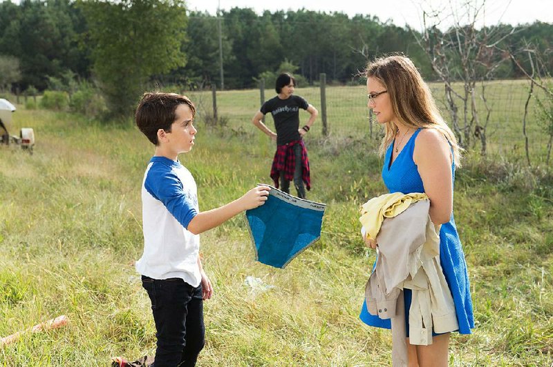 Greg Heffley (Jason Drucker) explains the meaning of underpants to his mom, Susan (Alicia Silverstone), while his mean older brother, Roderick (Charlie Wright), looks on in Diary of a Wimpy Kid: The Long Haul. 
