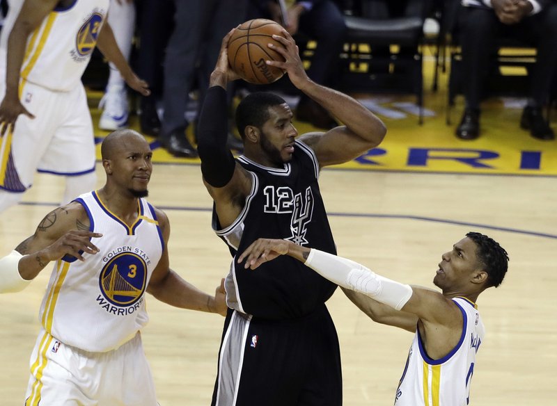 San Antonio Spurs' LaMarcus Aldridge (12) is defended by Golden State Warriors' Patrick McCaw, right, and David West (3) during the first half of Game 2 of the NBA basketball Western Conference finals, Tuesday, May 16, 2017, in Oakland, Calif. (AP Photo/Marcio Jose Sanchez)