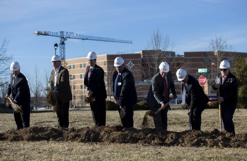 Officials turn dirt on Jan. 28, 2016, during a ground breaking for a new medical plaza to be built near Washington Regional Medical Center in Fayetteville.