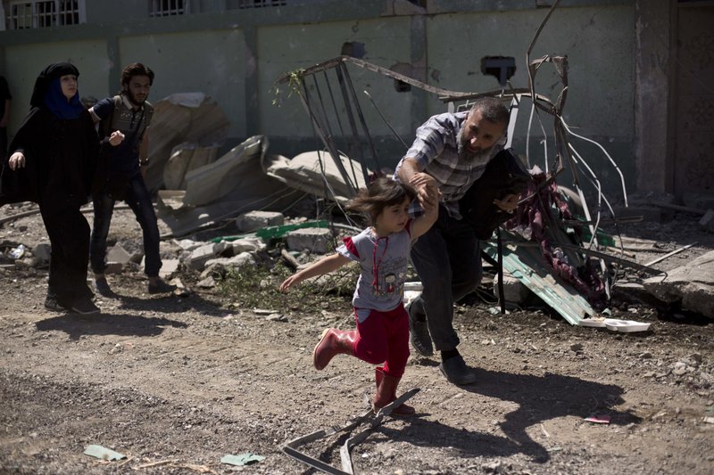 A man rushes his daughter to safety while fleeing the al-Rifai neighborhood as Iraqi special forces battle Islamic State militants, in western Mosul, Iraq, Wednesday, May 17, 2017. 